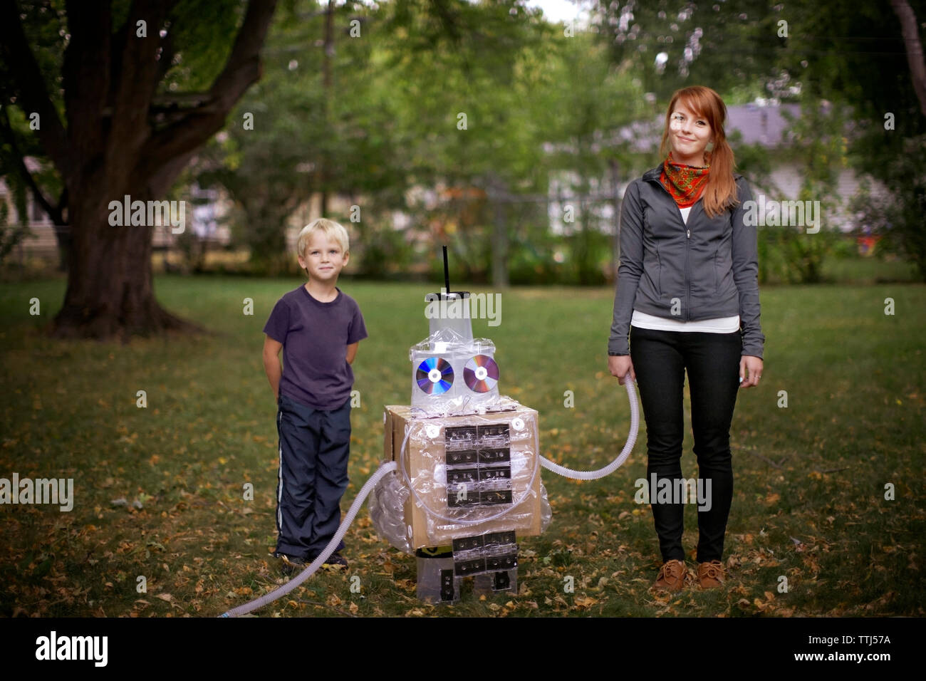 Portrait brother and sister standing with robot at park Stock Photo - Alamy