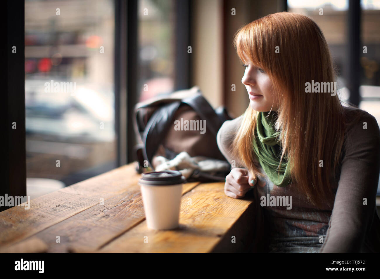 Woman looking down while sitting in cafe Stock Photo