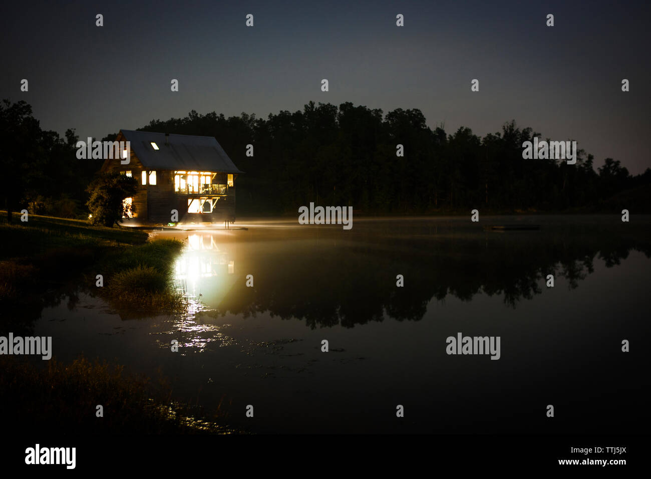 Cottage in lake against clear sky at night Stock Photo
