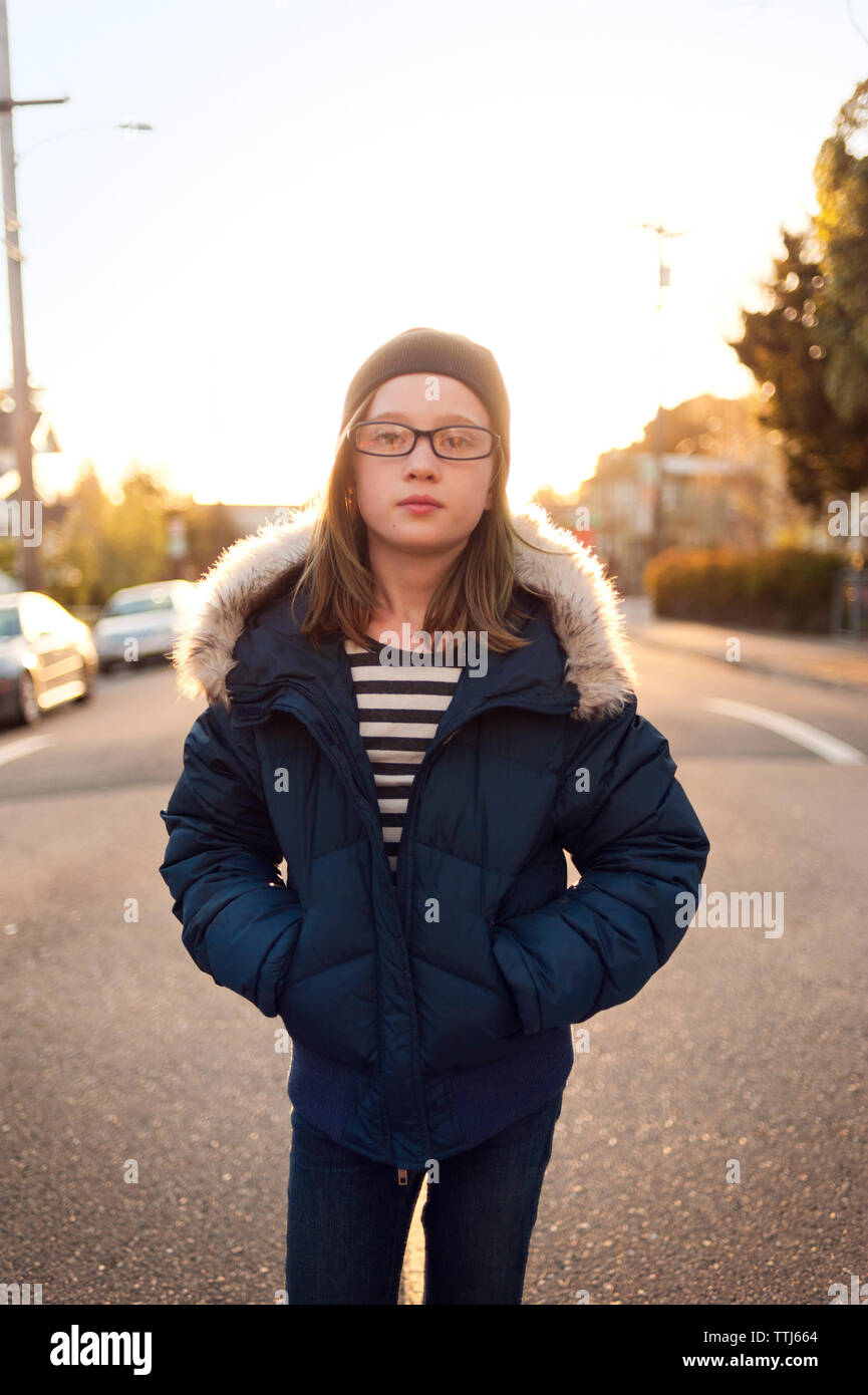 Portrait of girl in warm clothing standing on road against sky Stock Photo