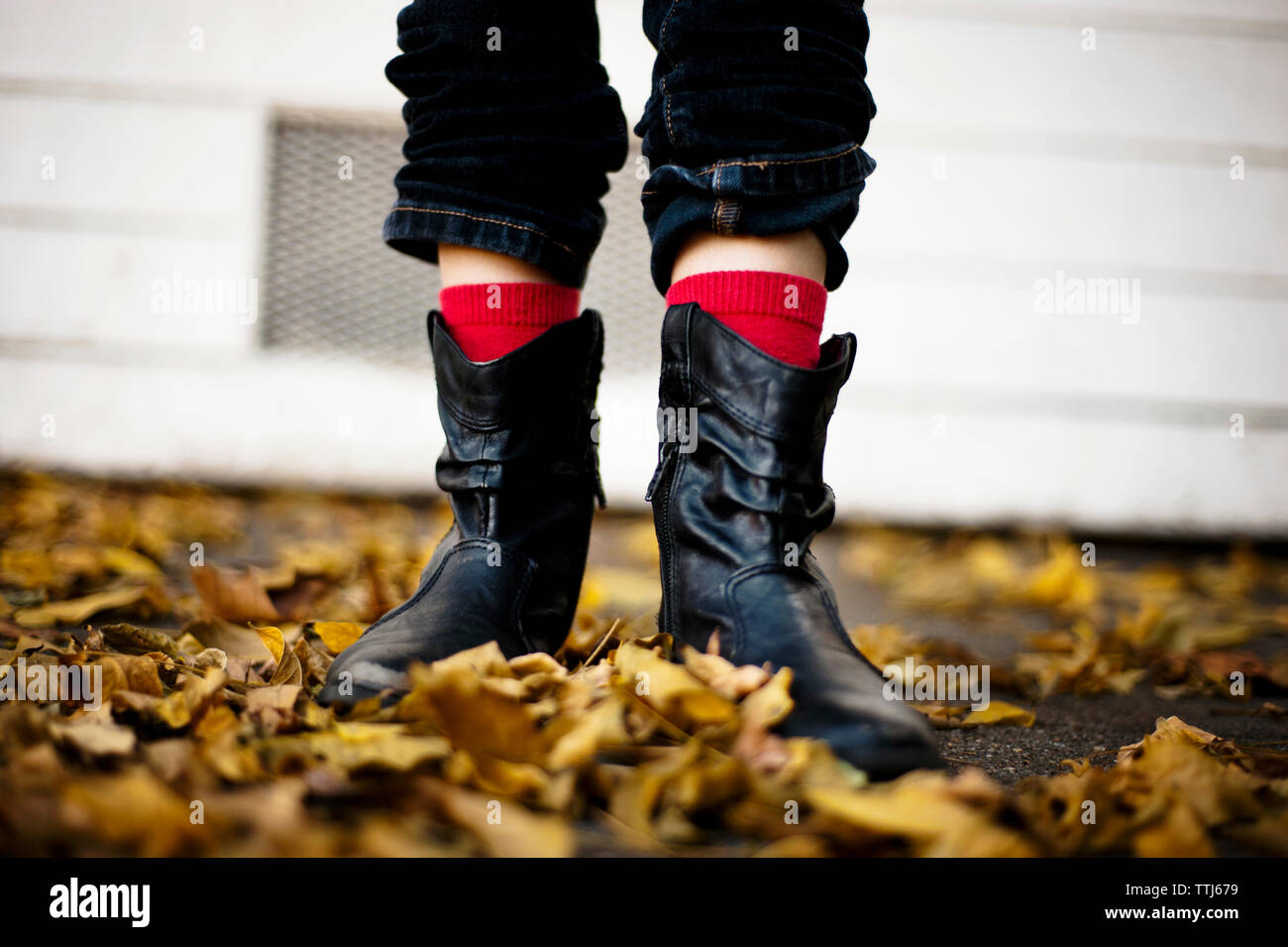 Low section of girl in rubber boot standing on field Stock Photo - Alamy