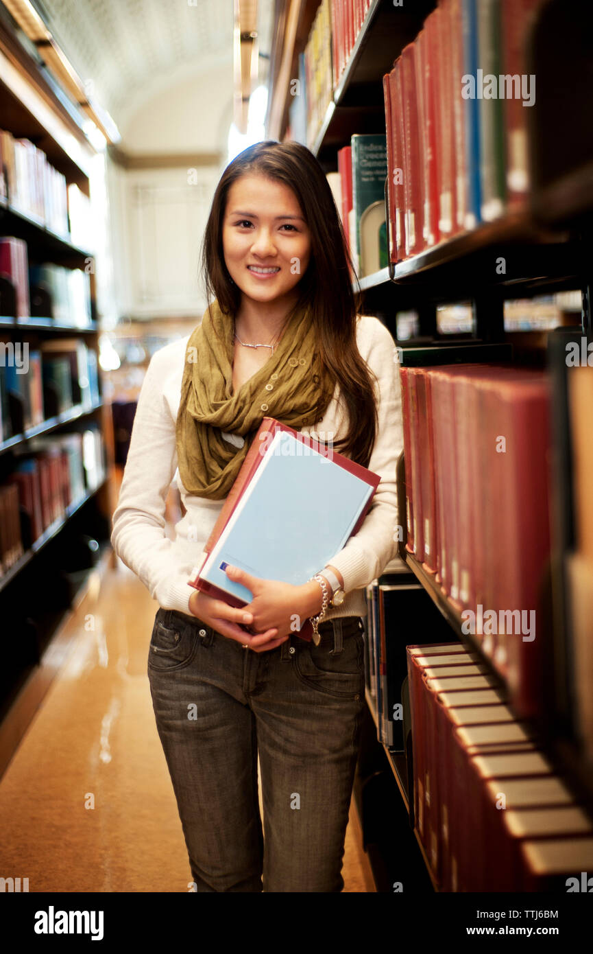 Portrait of woman standing in library Stock Photo