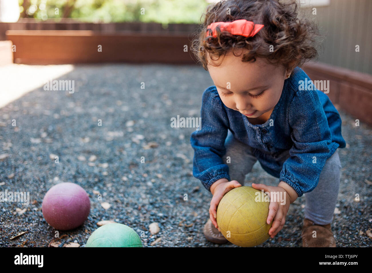 Baby holding ball in backyard Stock Photo