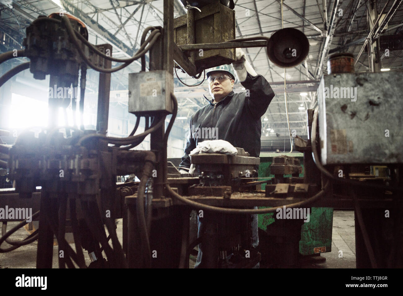 Man operating machinery in factory Stock Photo