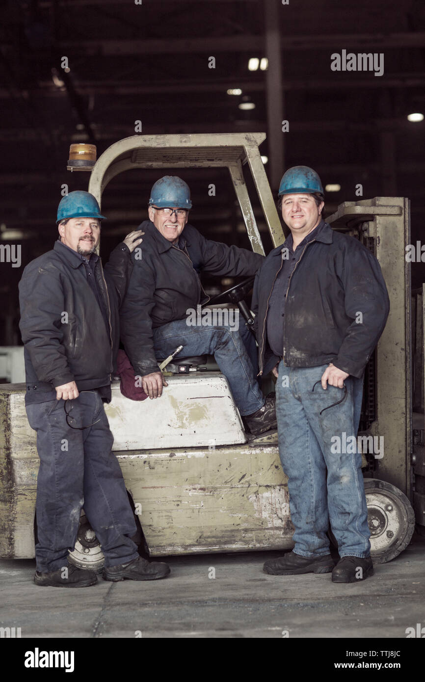 Portrait of workers with forklift in warehouse Stock Photo