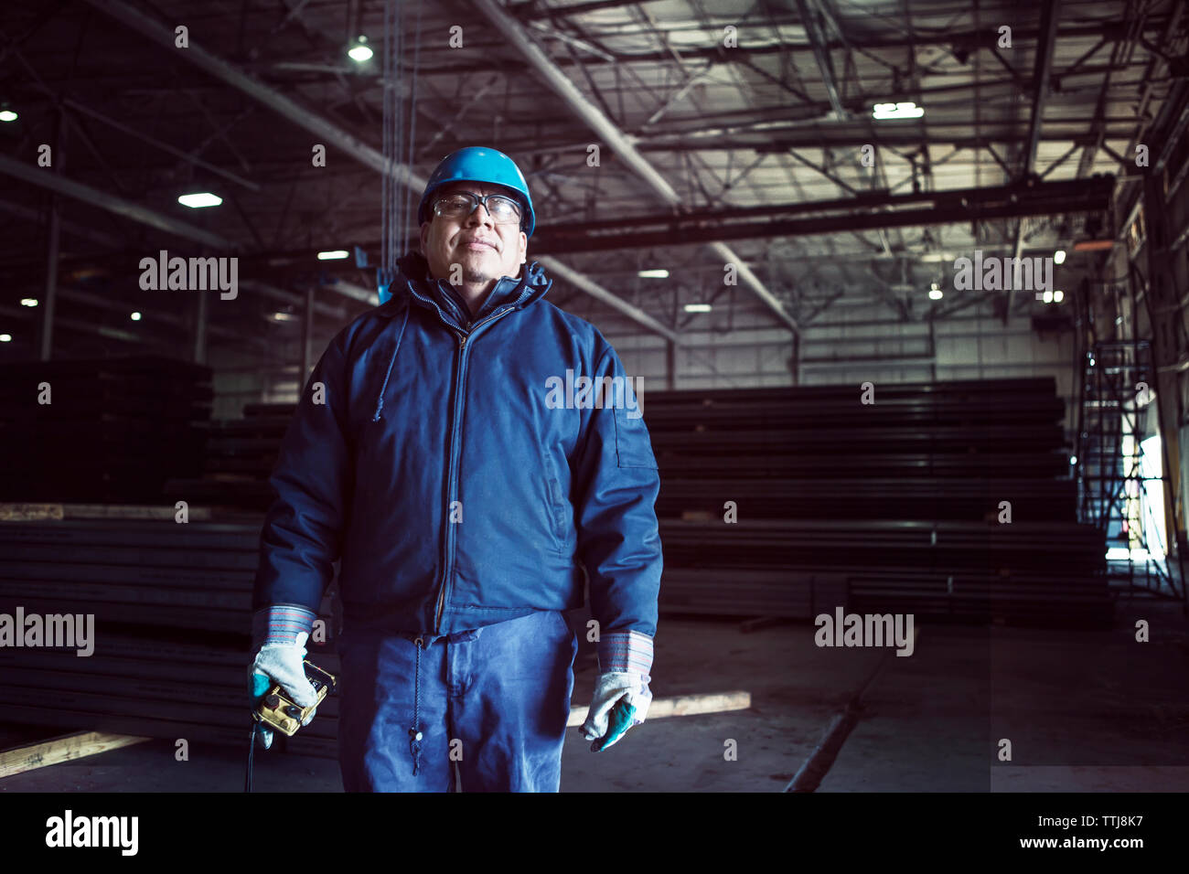 Portrait of worker holding remote control standing in factory Stock Photo