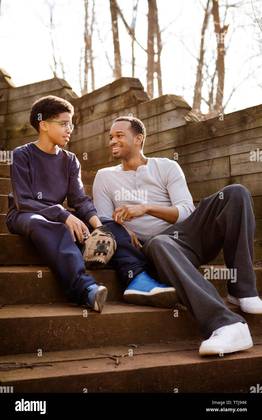 Father and son talking while sitting on steps Stock Photo