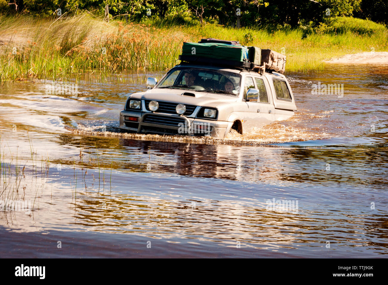 Couple enjoying off-road vehicle ride in pond Stock Photo