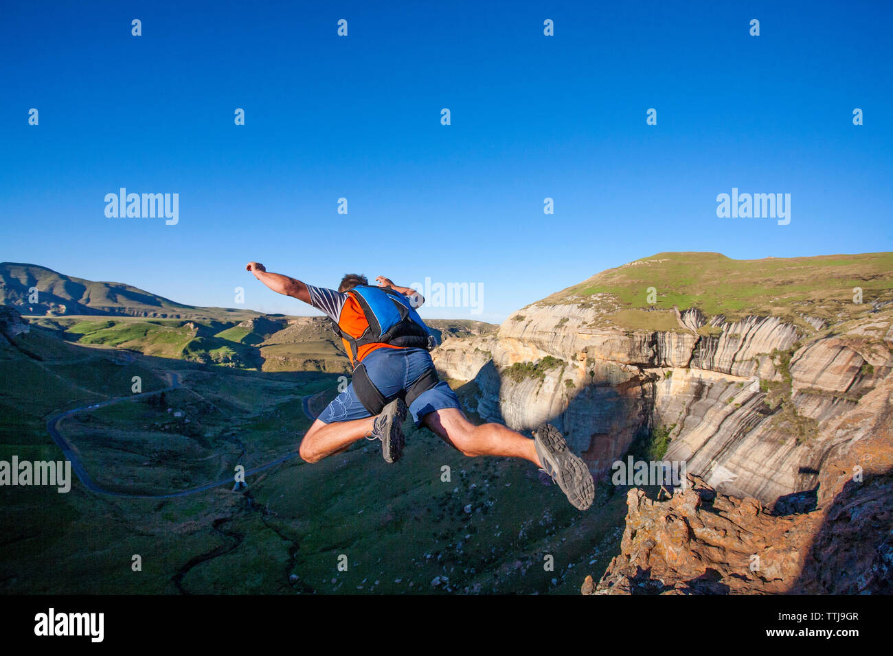 Rear view of man BASE jumping from mountain Stock Photo Alamy