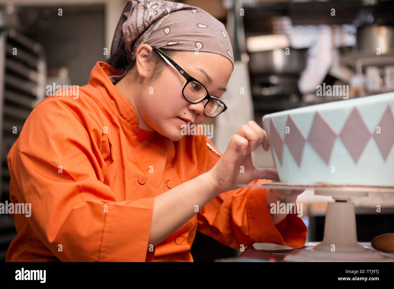 Woman decorating cake at store Stock Photo