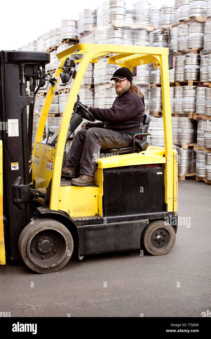 Man riding forklift at warehouse Stock Photo