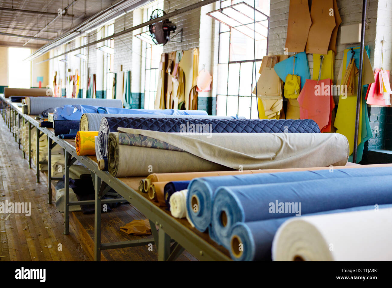 Fabric rolls on table in factory Stock Photo