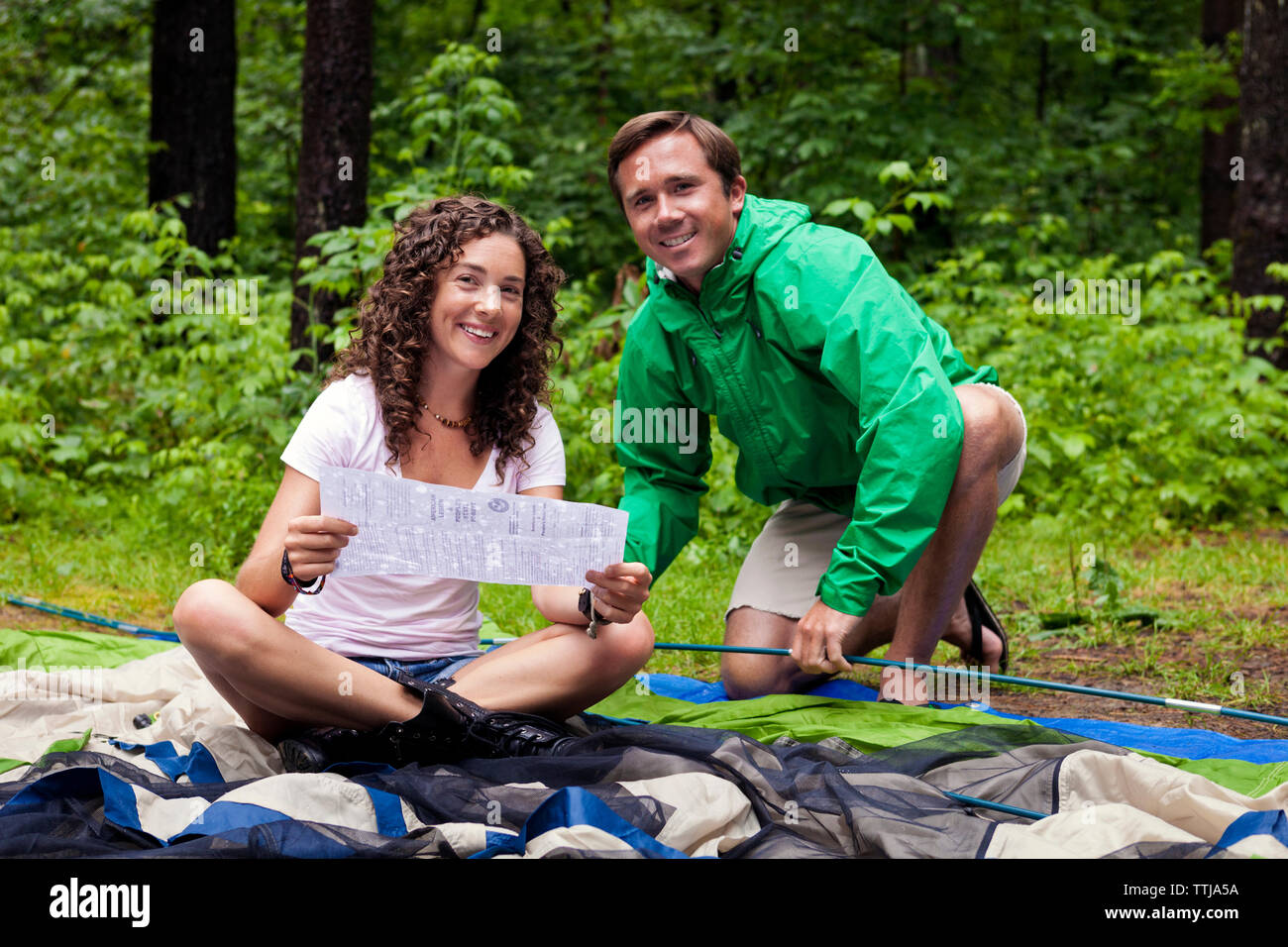 Portrait of happy friends with instruction for tent Stock Photo