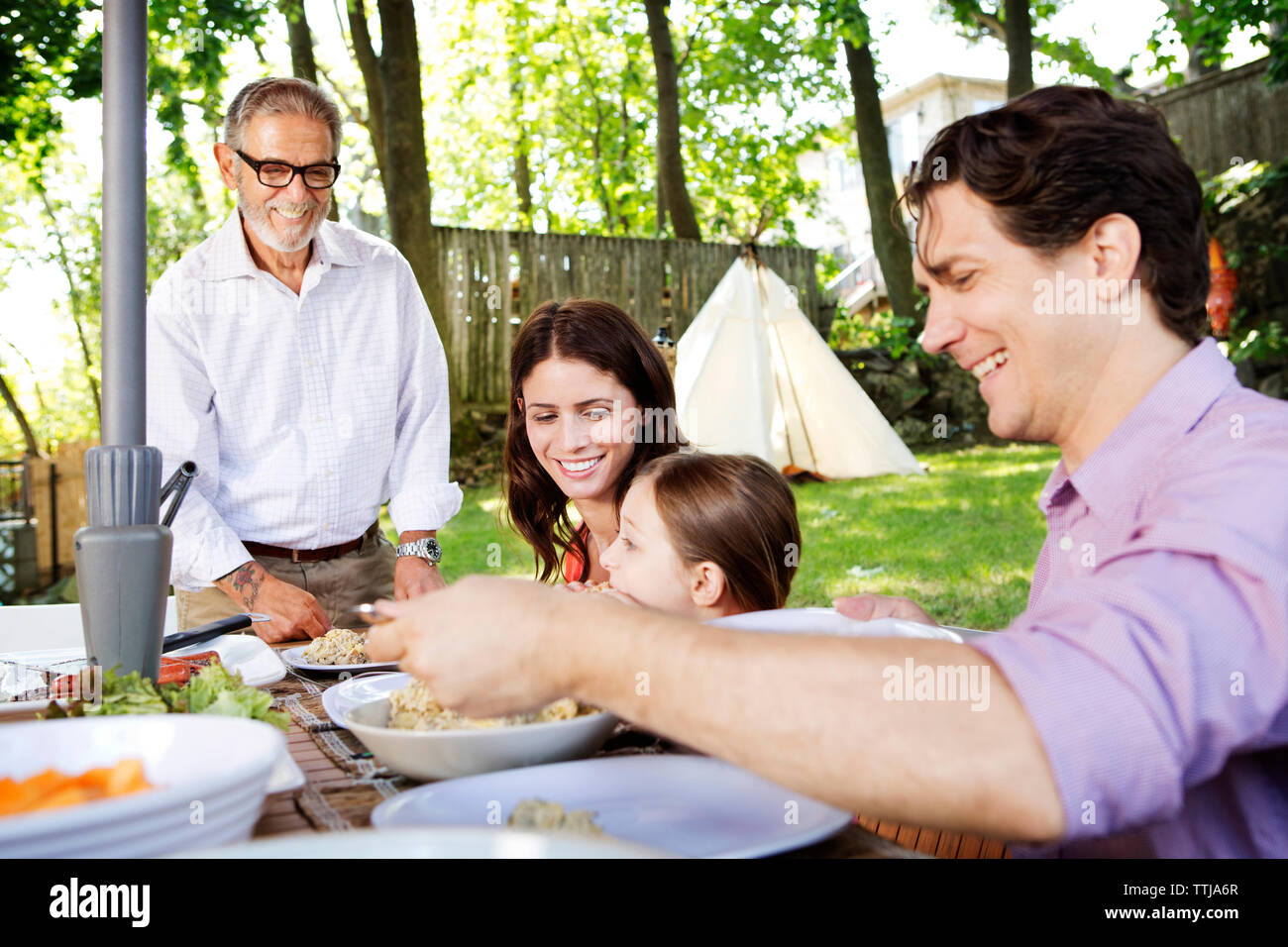 Family enjoying food in lawn Stock Photo