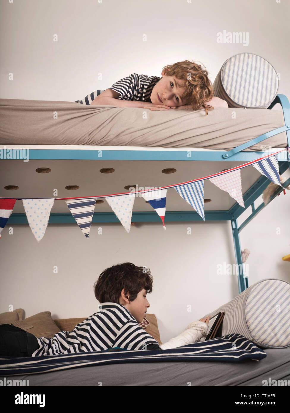Brothers lying on bunkbed at home Stock Photo