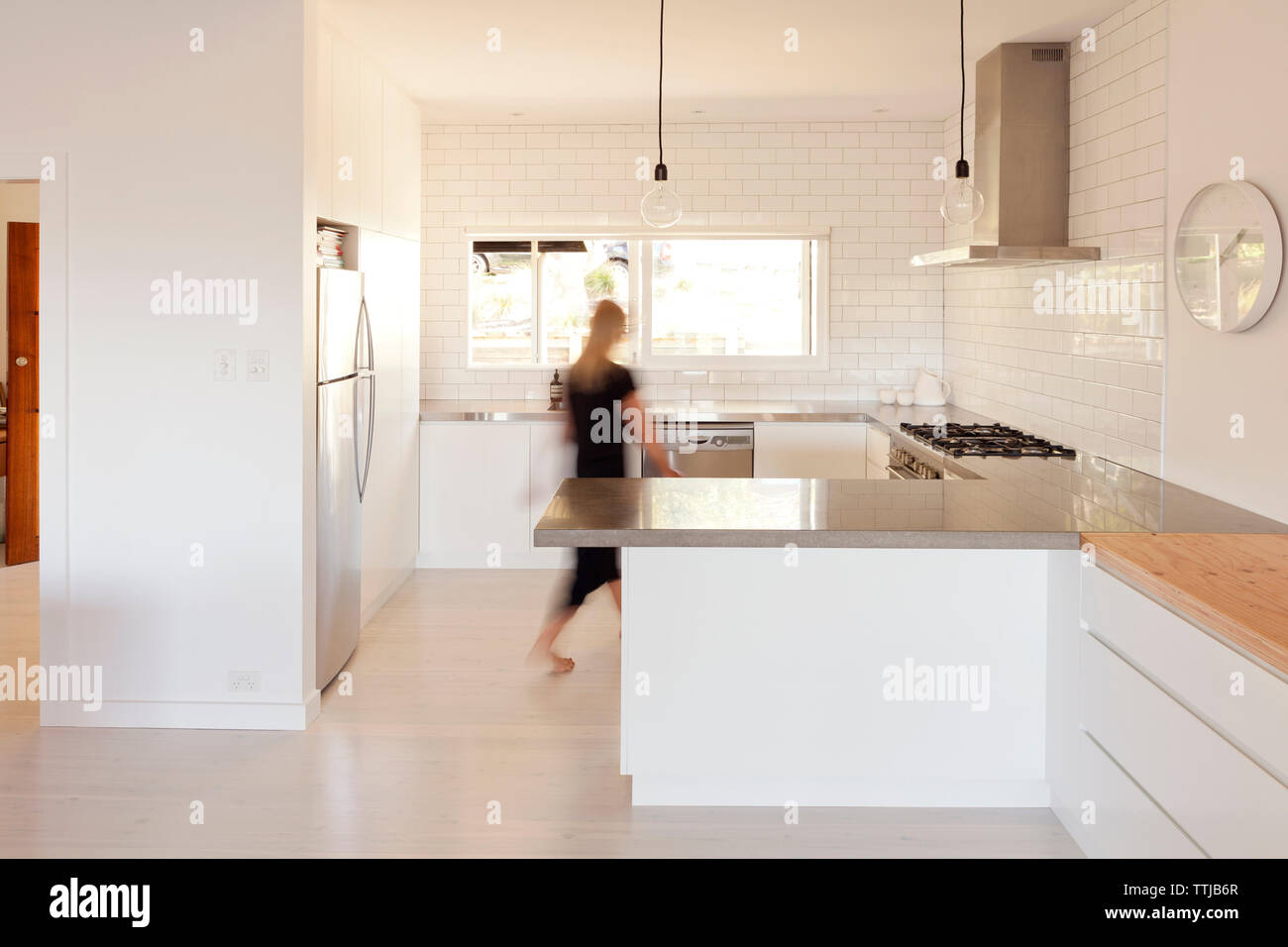 Woman walking in kitchen Stock Photo Alamy