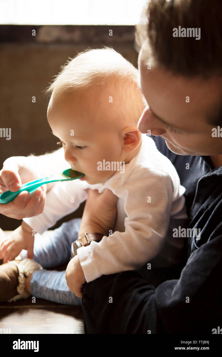 Mother wearing sock while son lying on bed at home Stock Photo Alamy