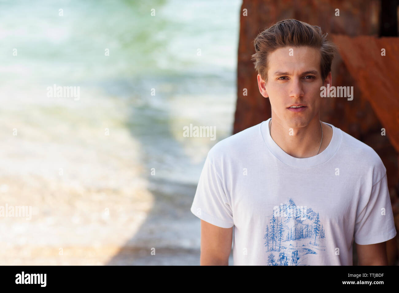 Young man standing front wall hi-res stock photography and images - Alamy