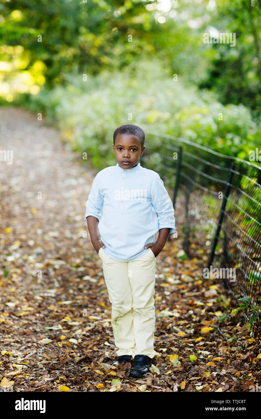 Portrait of boy with hands in pockets standing in park Stock Photo