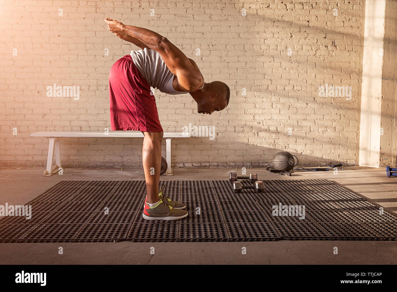 Man practicing stretching exercise in gym Stock Photo