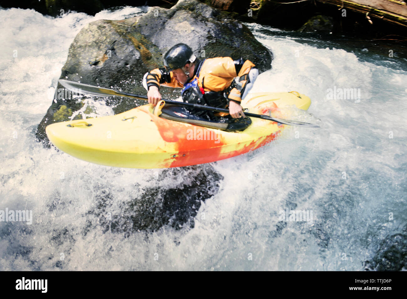 Man kayaking by rocks in river Stock Photo - Alamy