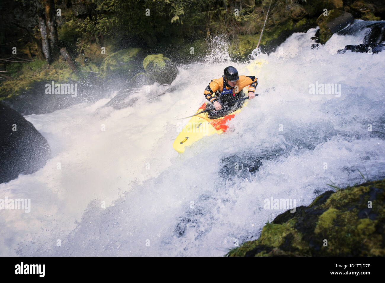 Man kayaking by rocks in river Stock Photo - Alamy