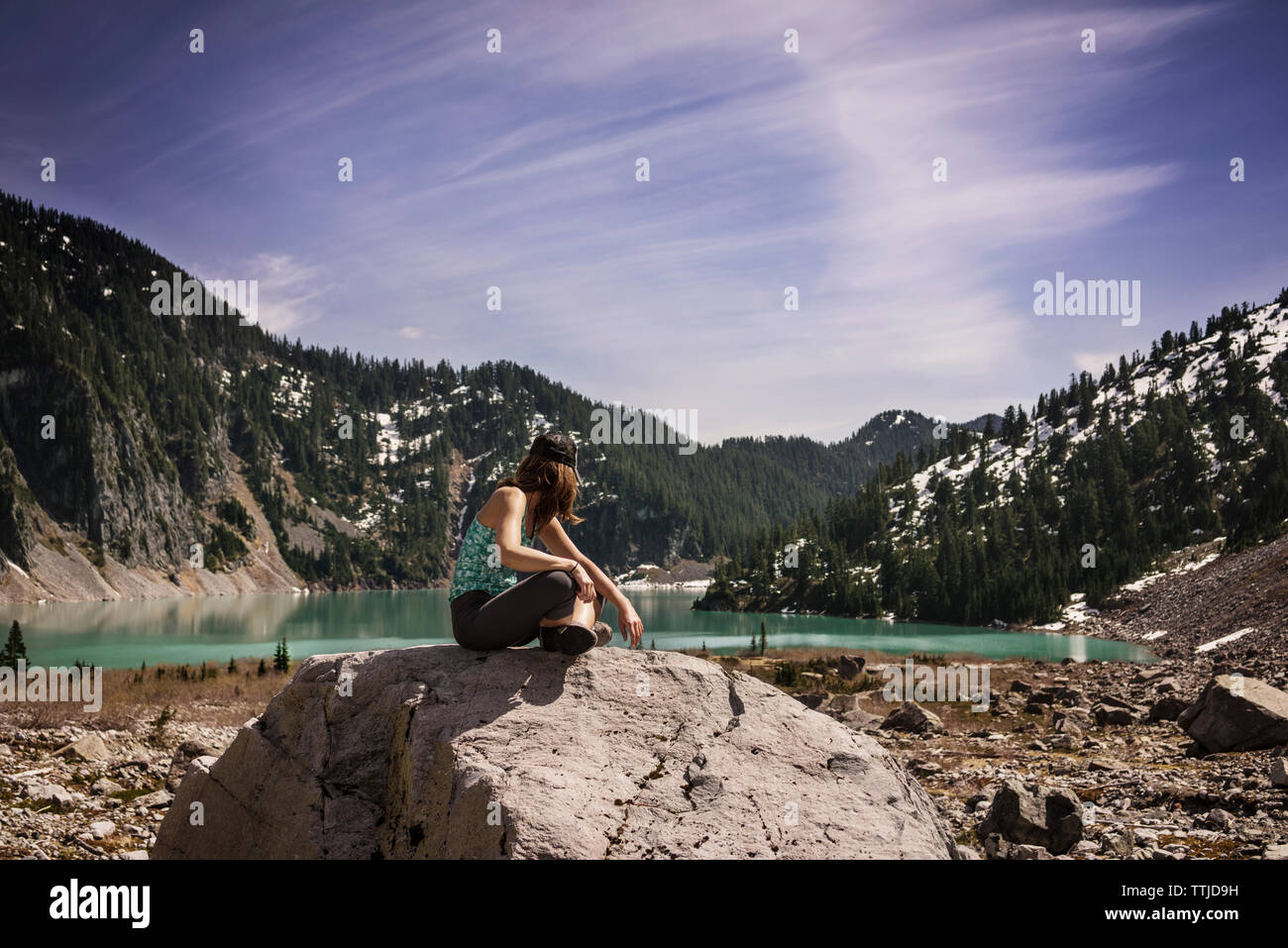 Woman sitting rock lake hi-res stock photography and images - Alamy