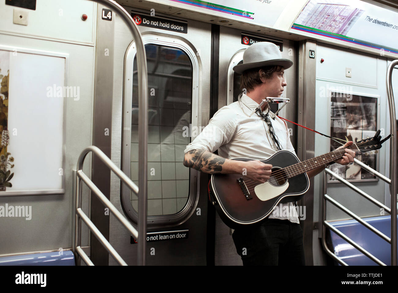 Street musician playing guitar in subway train Stock Photo Alamy