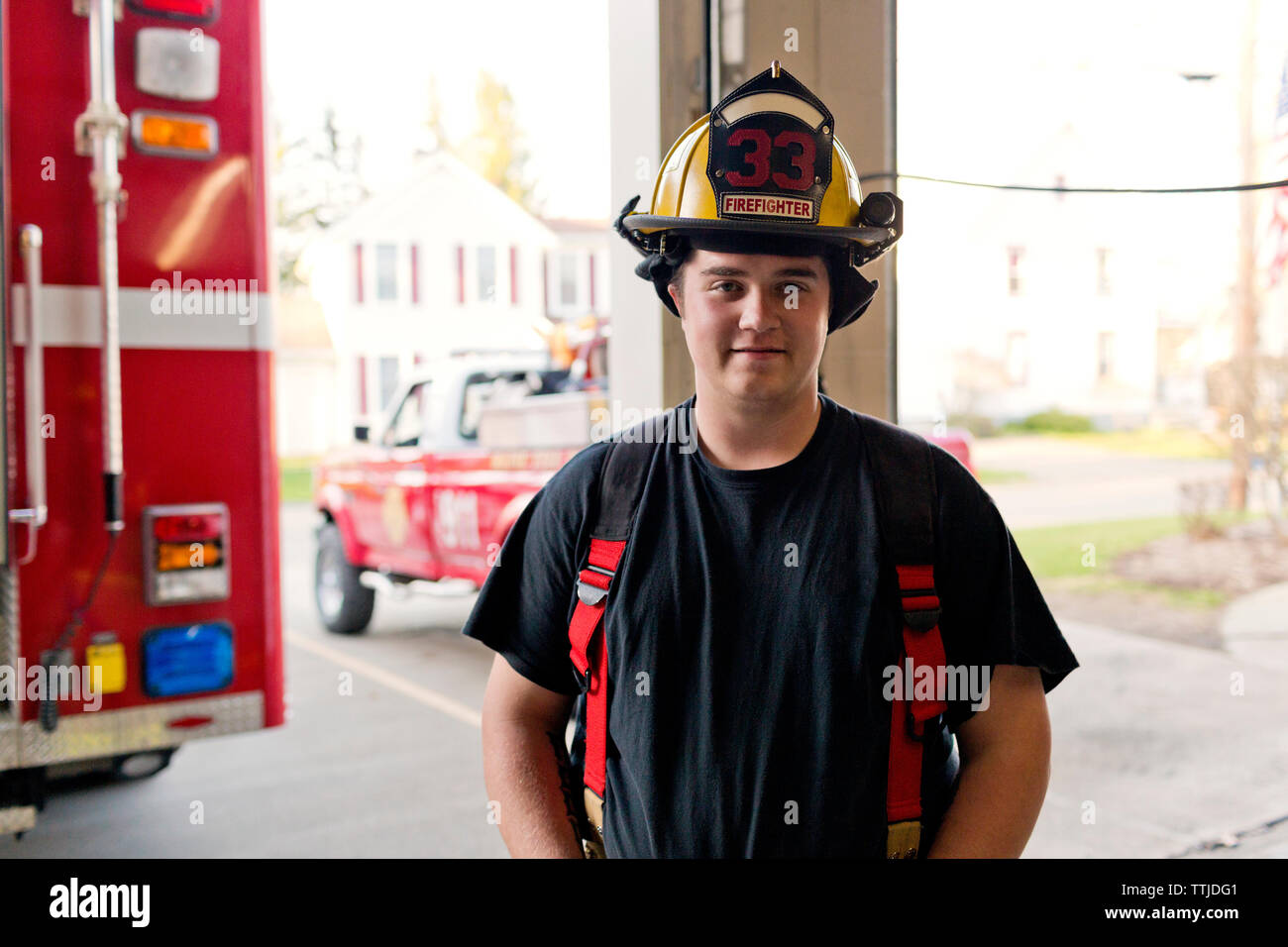 Portrait of fireman standing at fire station Stock Photo