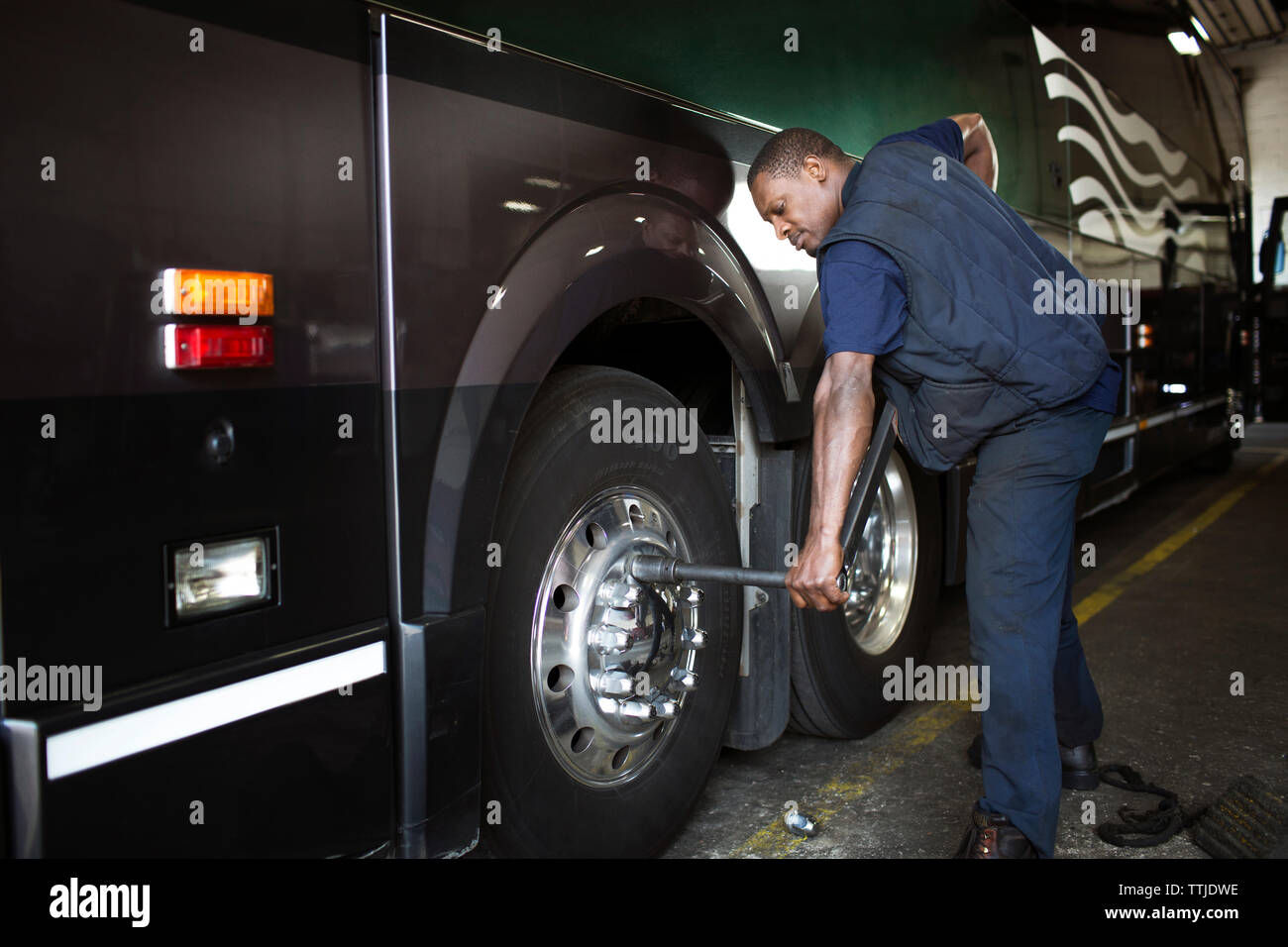 Mechanic repairing engine of bus Stock Photo