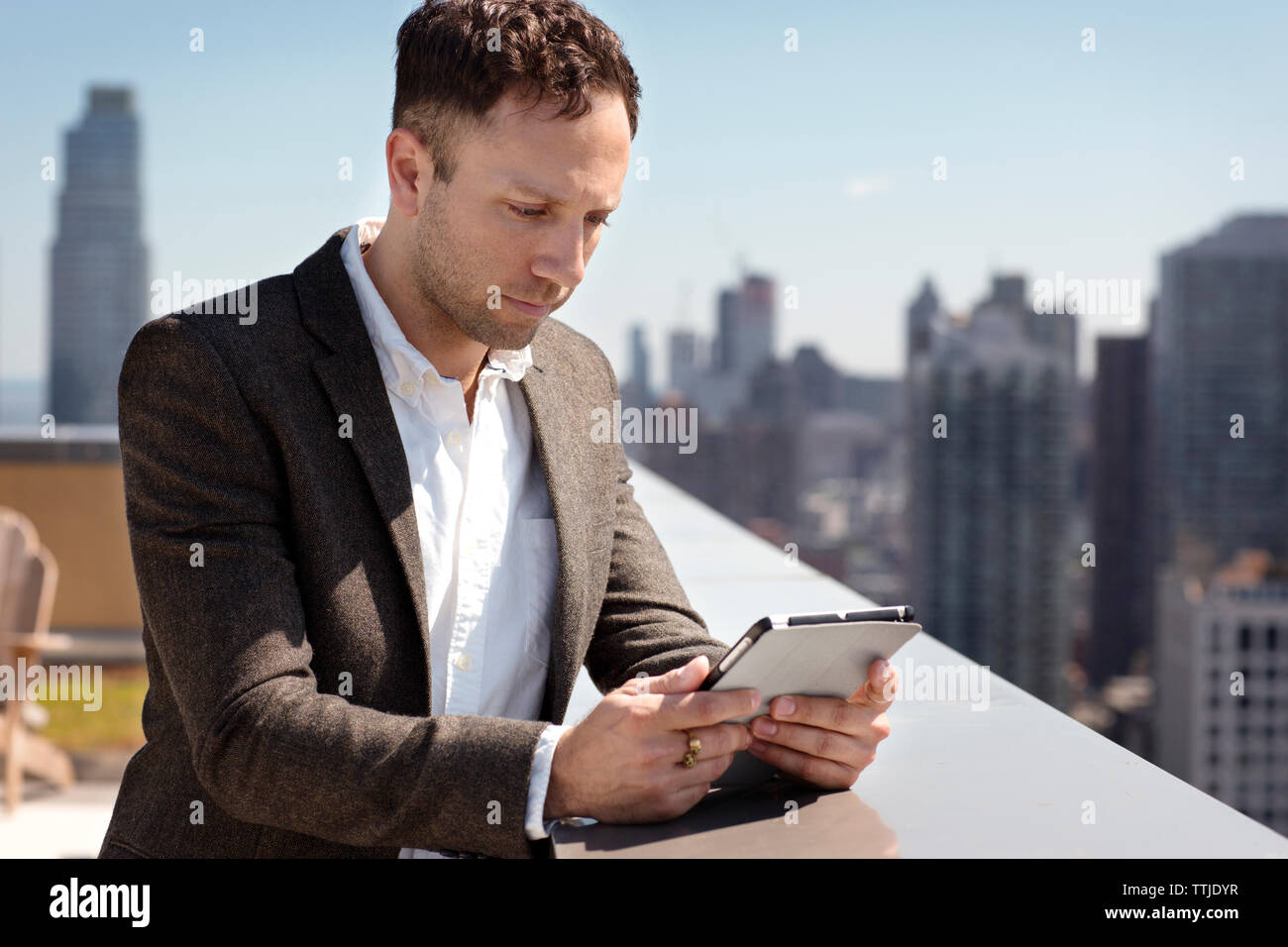 businessman using tablet computer on building terrace Stock Photo