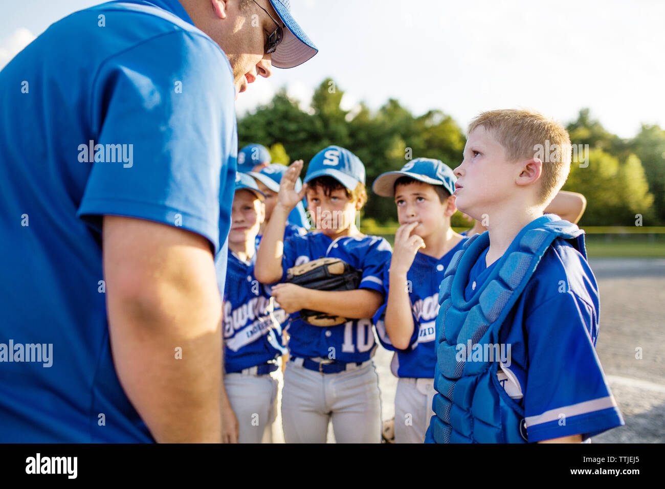 Coach guiding players on field Stock Photo