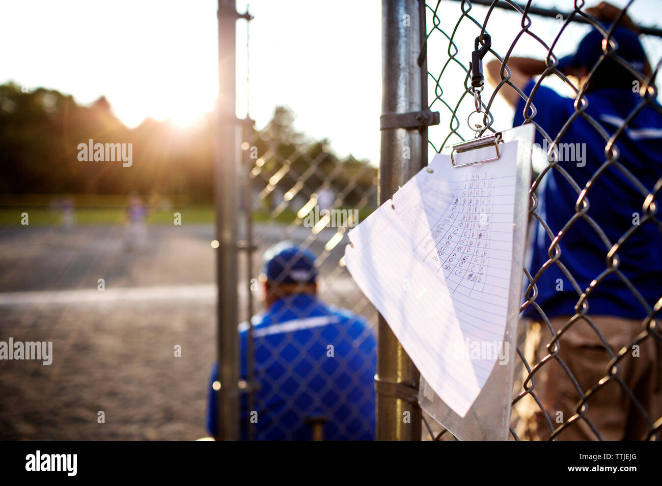 Score card hanging on fence with coach in background Stock Photo