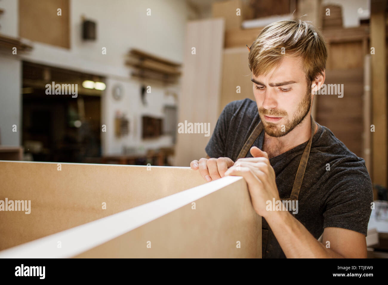 Man working on wooden plank in carpentry workshop Stock Photo