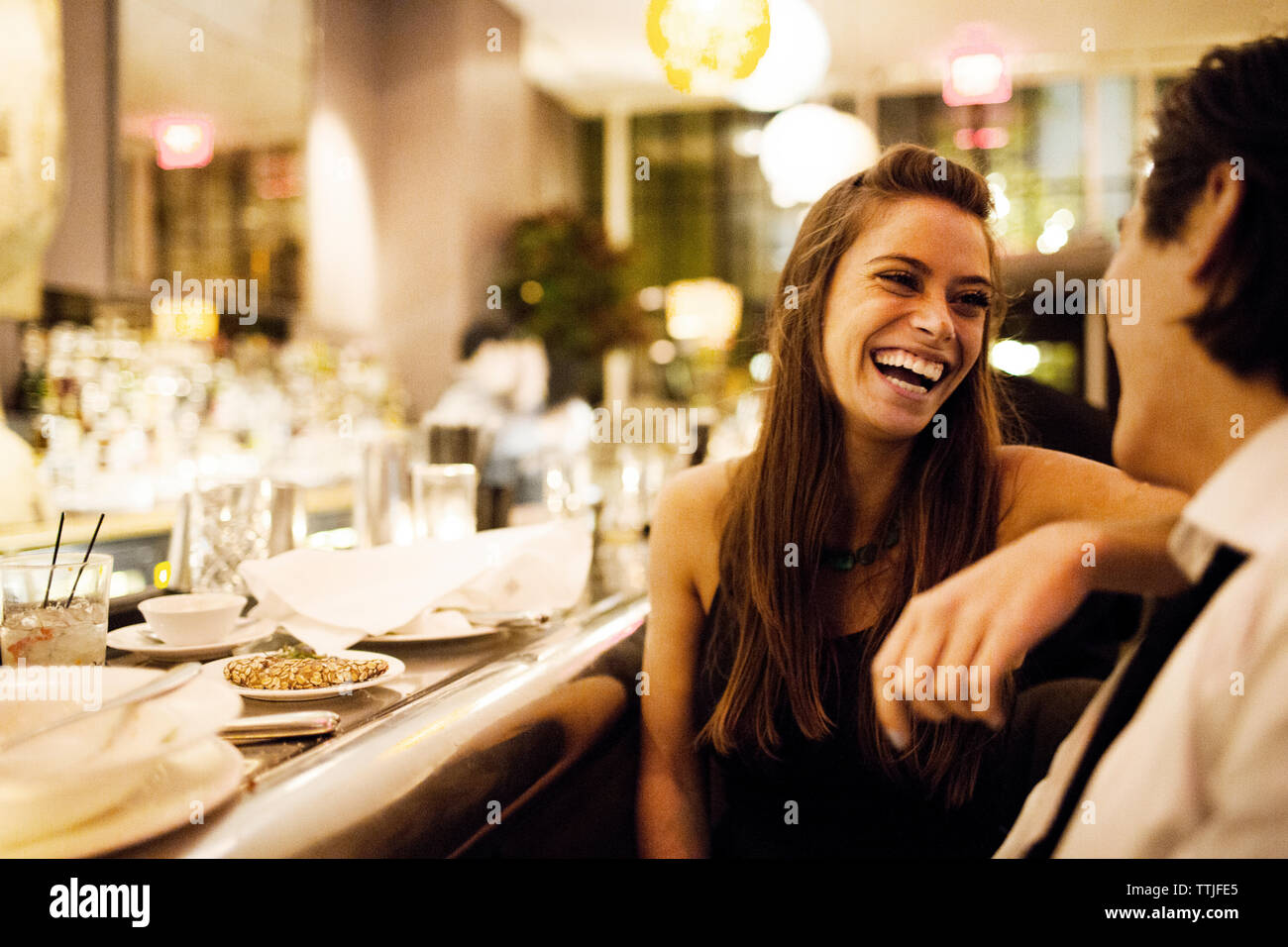 Happy couple talking while sitting in restaurant Stock Photo