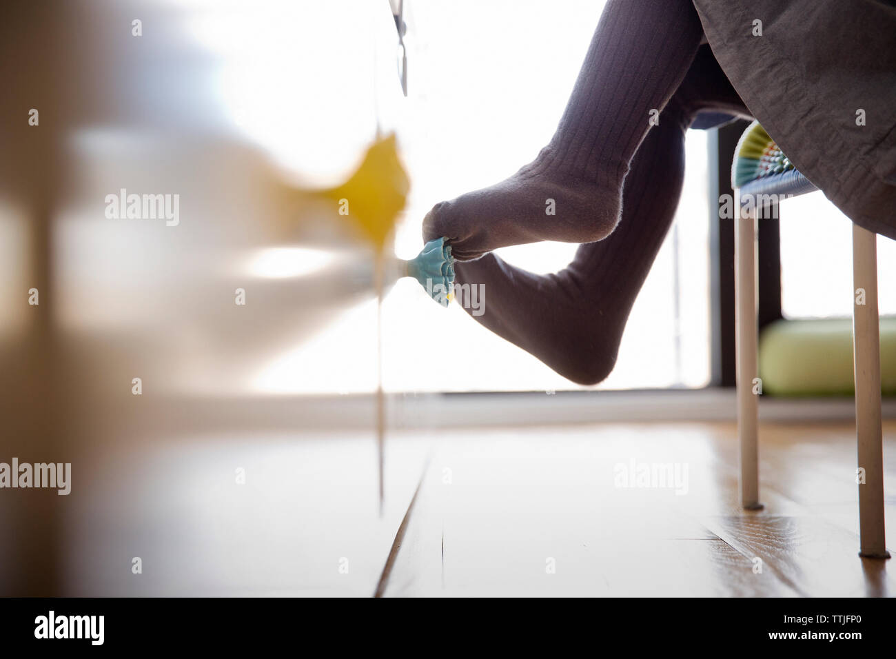 Low section of girl sitting on chair Stock Photo - Alamy