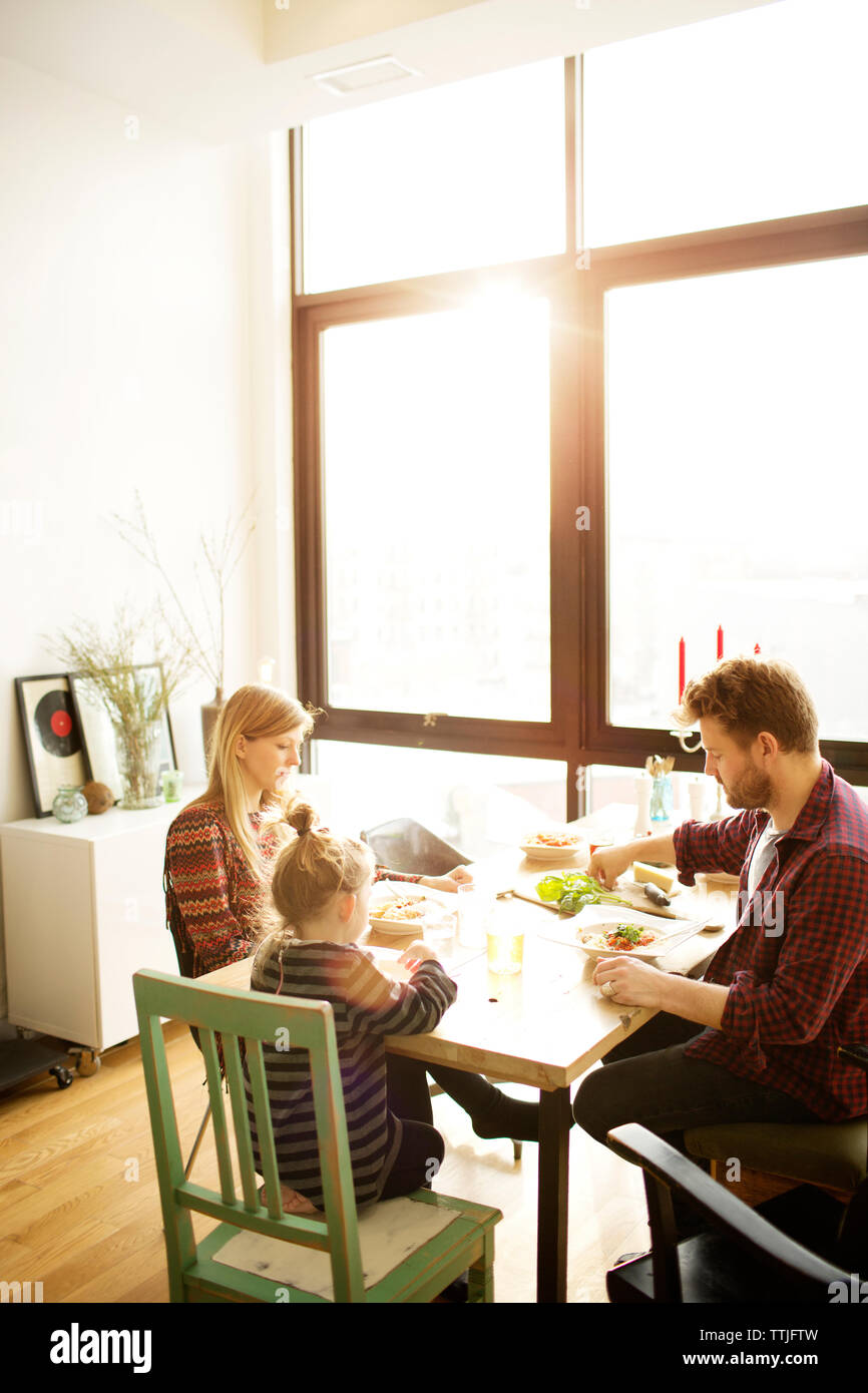 Happy family eating breakfast at dinning table in home Stock Photo - Alamy