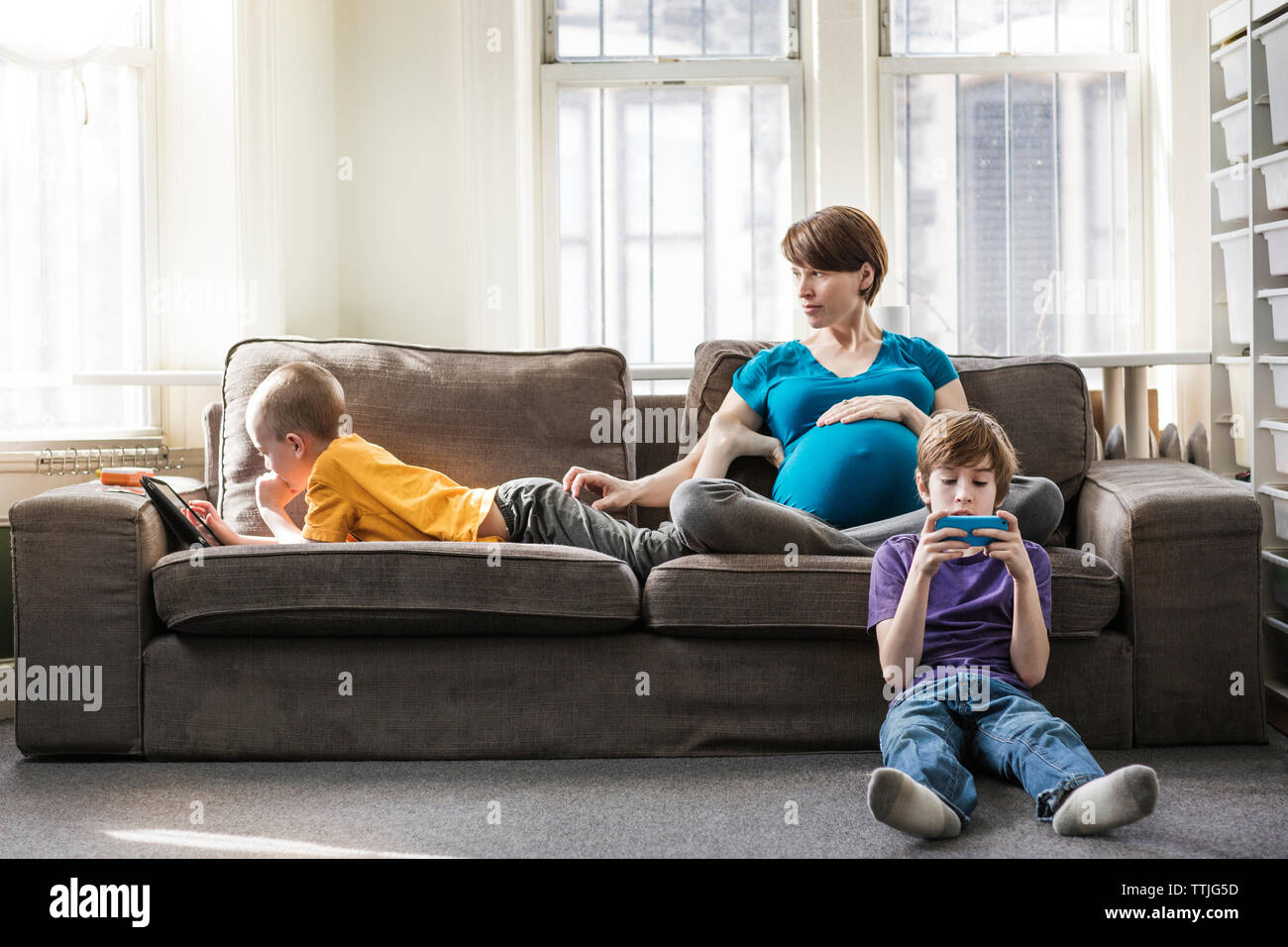 Pregnant woman with children at home Stock Photo