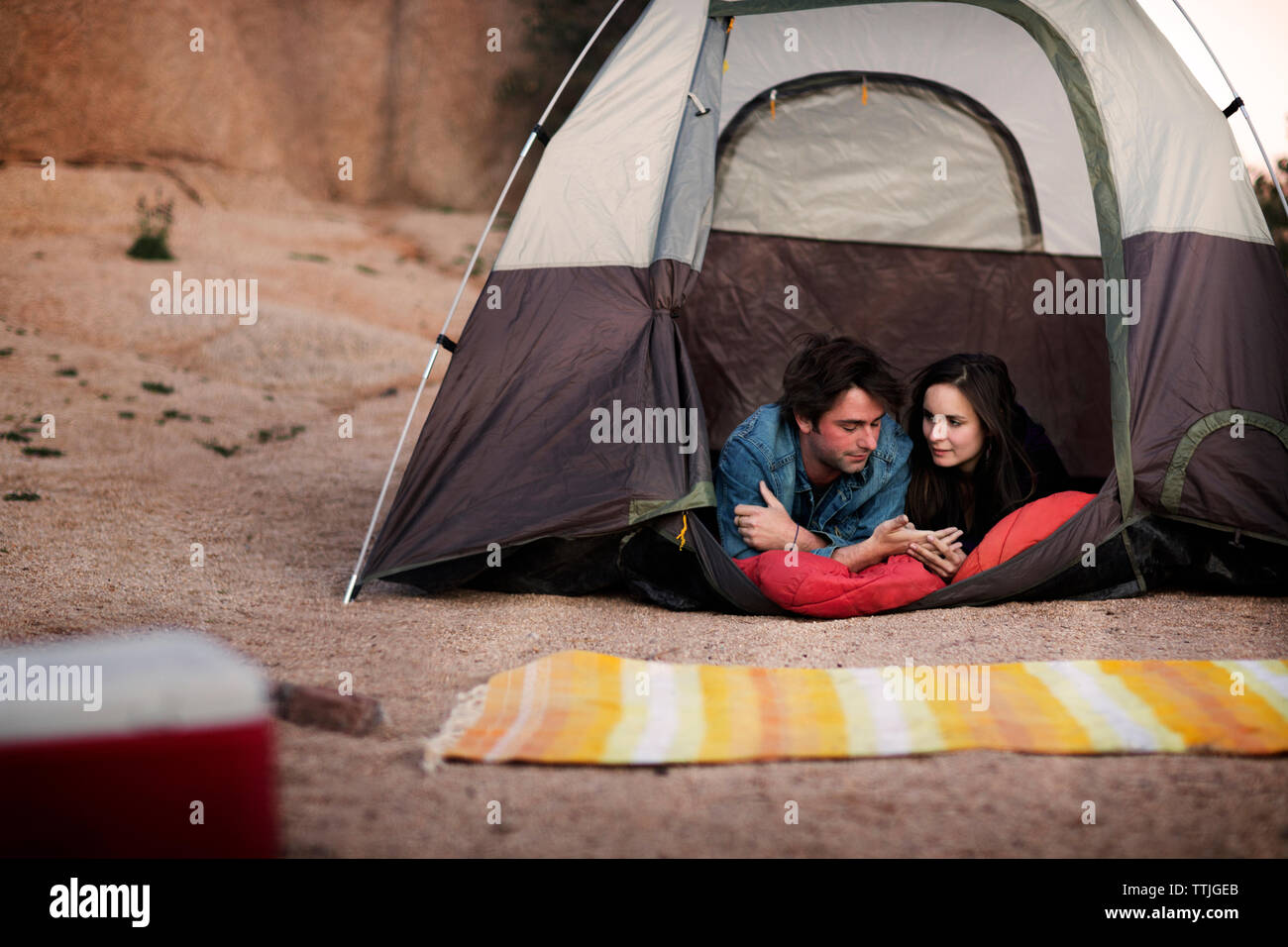 Couple talking while lying in tent Stock Photo