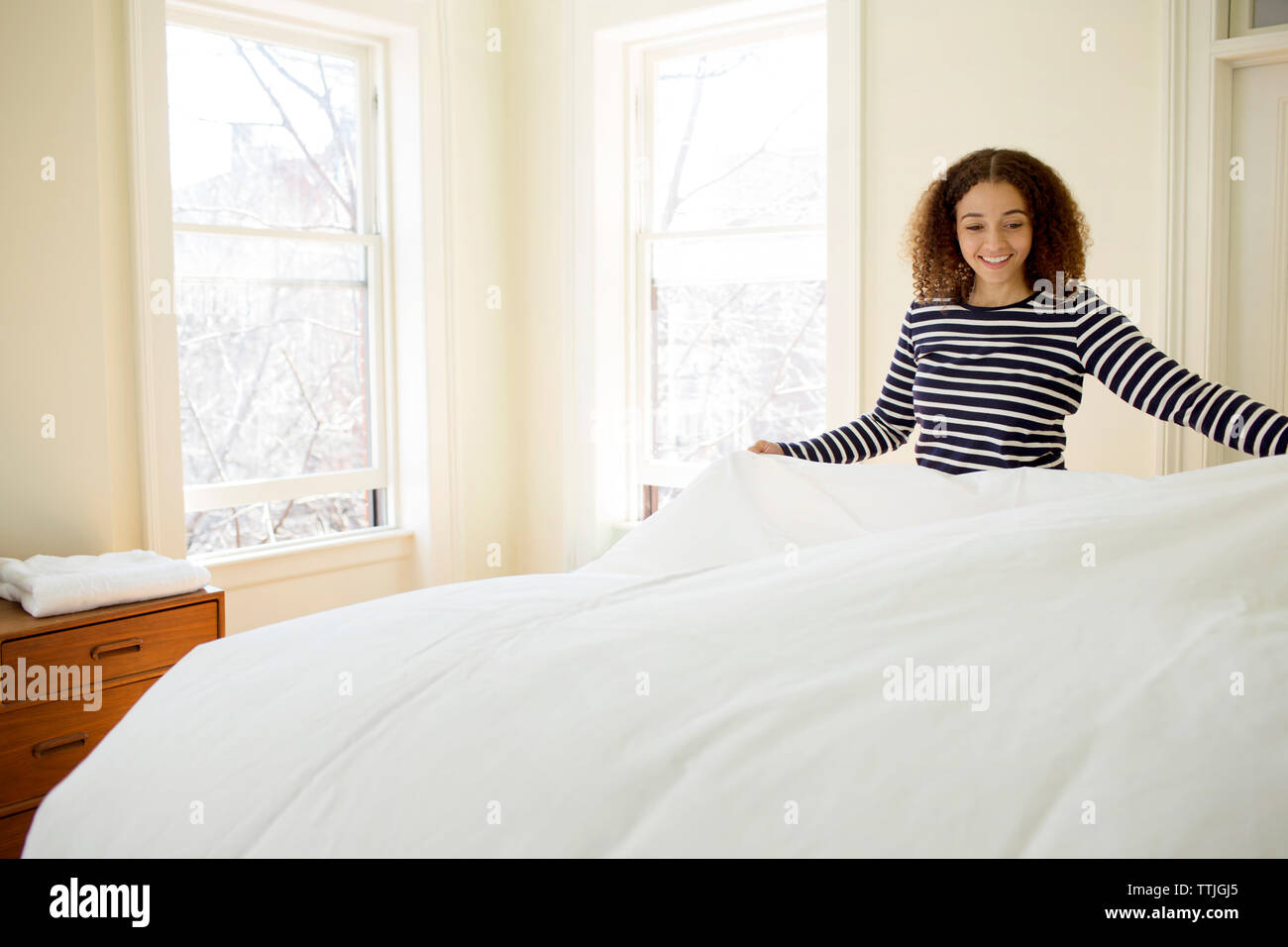 Happy Woman Putting Blanket On Bed At Home Stock Photo Alamy
