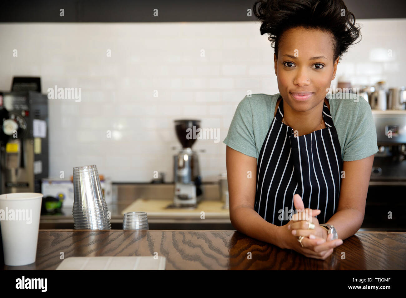 Portrait of confident owner standing at counter in cafe Stock Photo