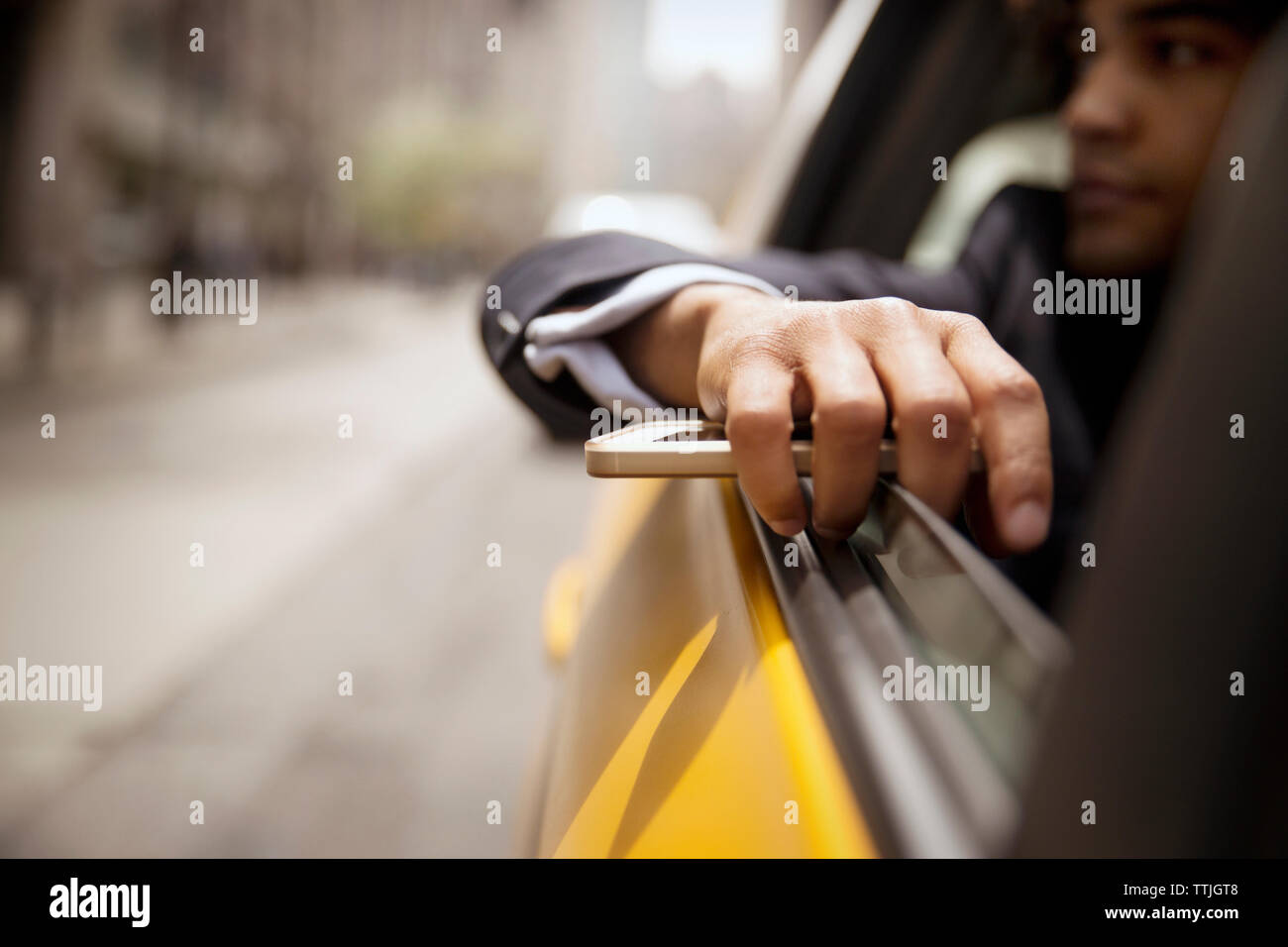 businessman holding smart phone while sitting in car Stock Photo