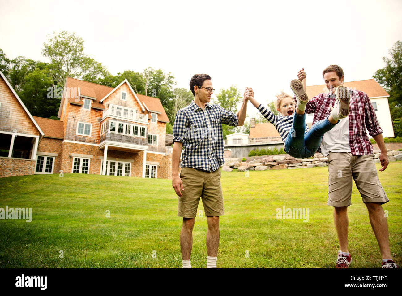 Happy Men Swinging Girl In Backyard Stock Photo 256106131 Alamy