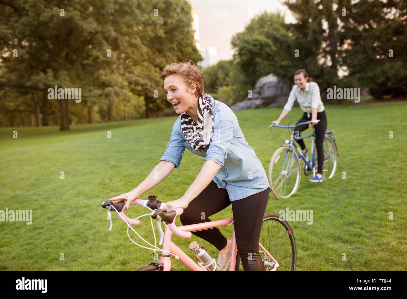 Happy women cycling in central Park Stock Photo