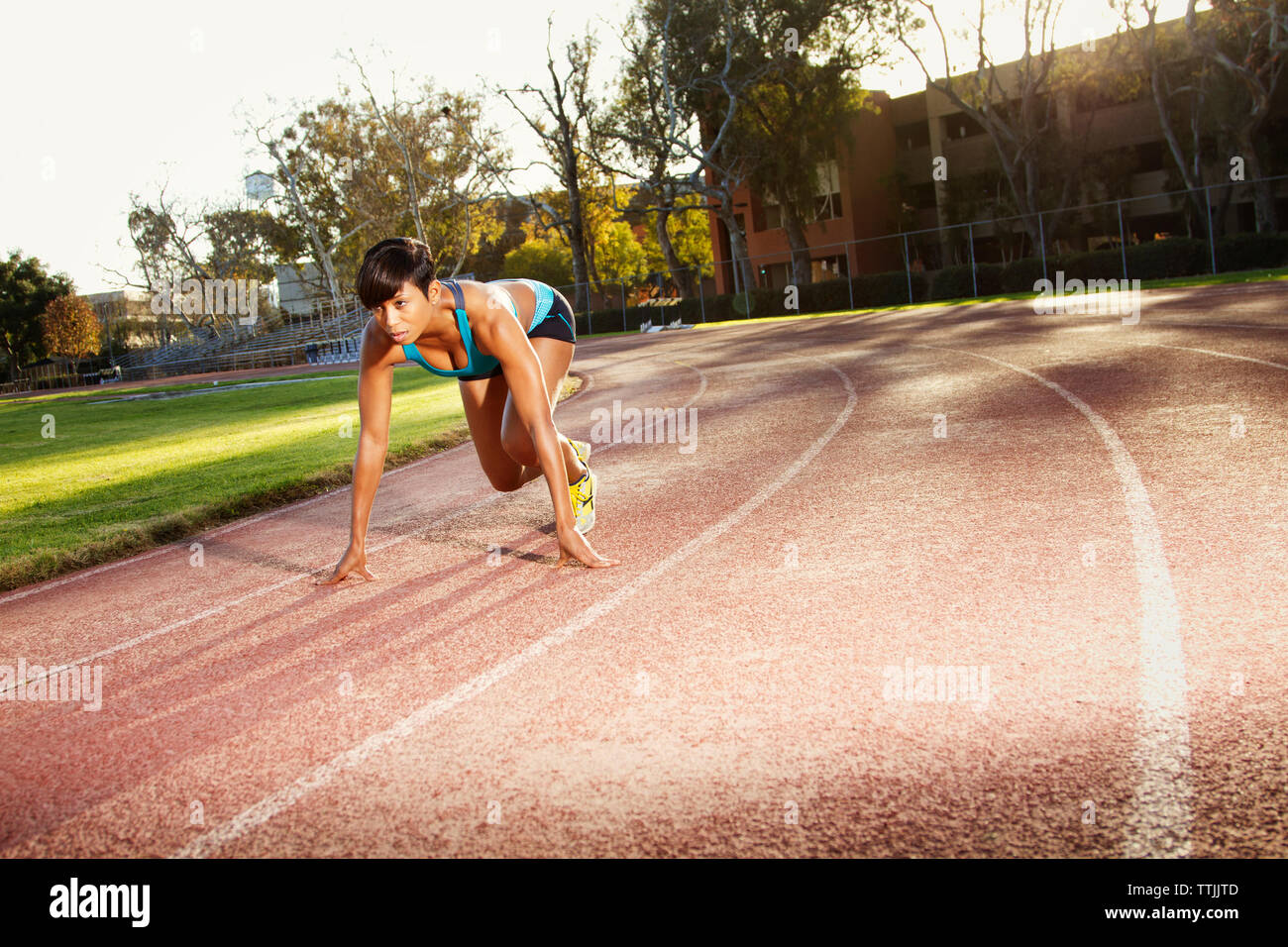 Woman preparing for running on sports track Stock Photo
