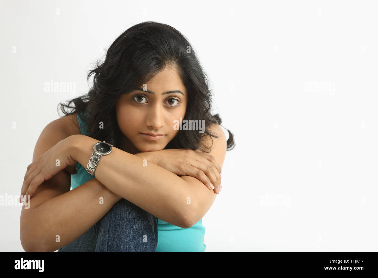 Portrait of an Indian woman hugging her knees Stock Photo