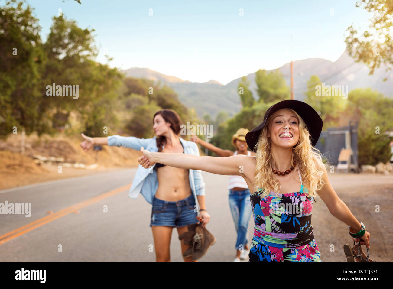 Women hailing while standing at road Stock Photo