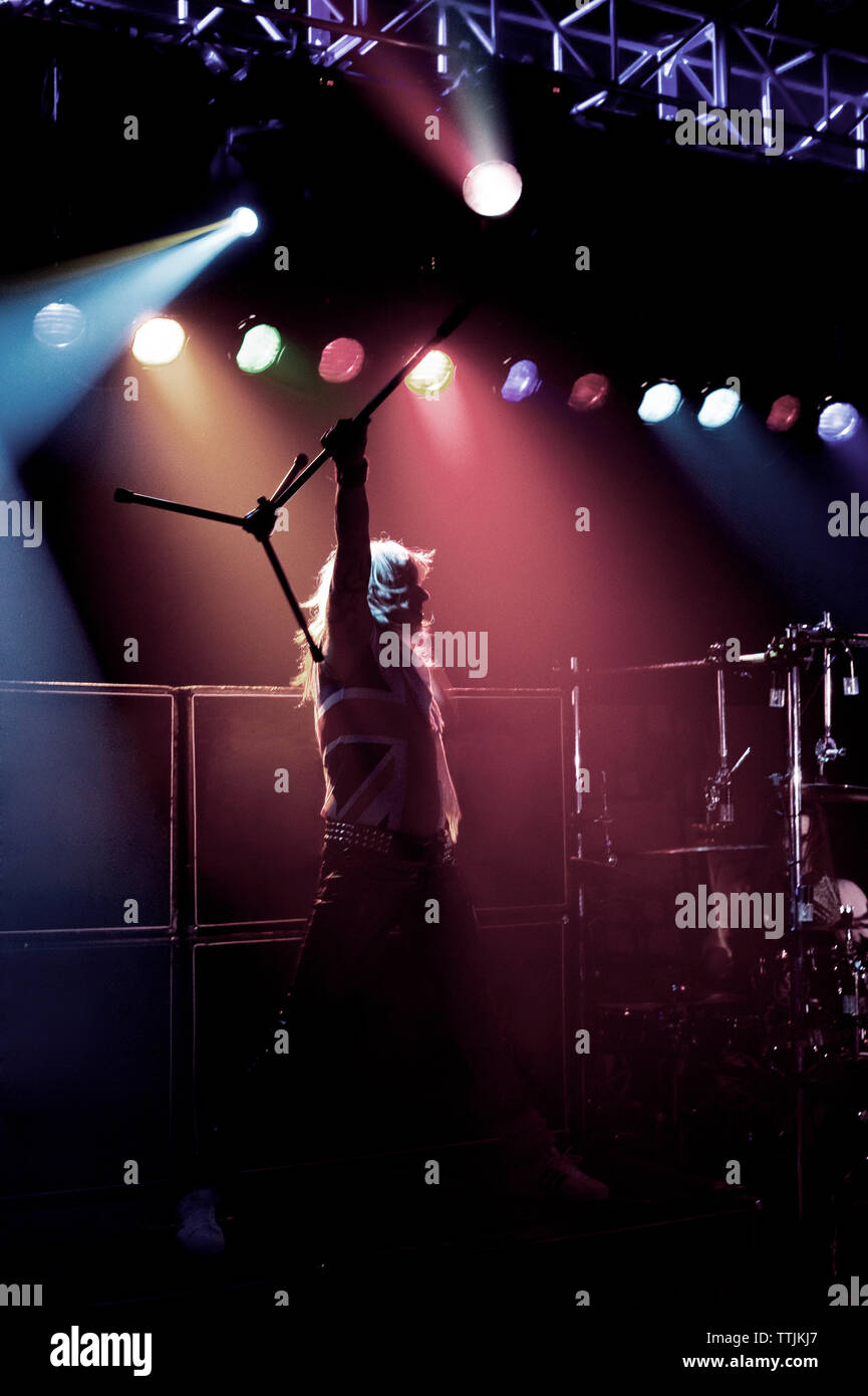 Man carrying microphone stand while standing on stage at concert Stock Photo