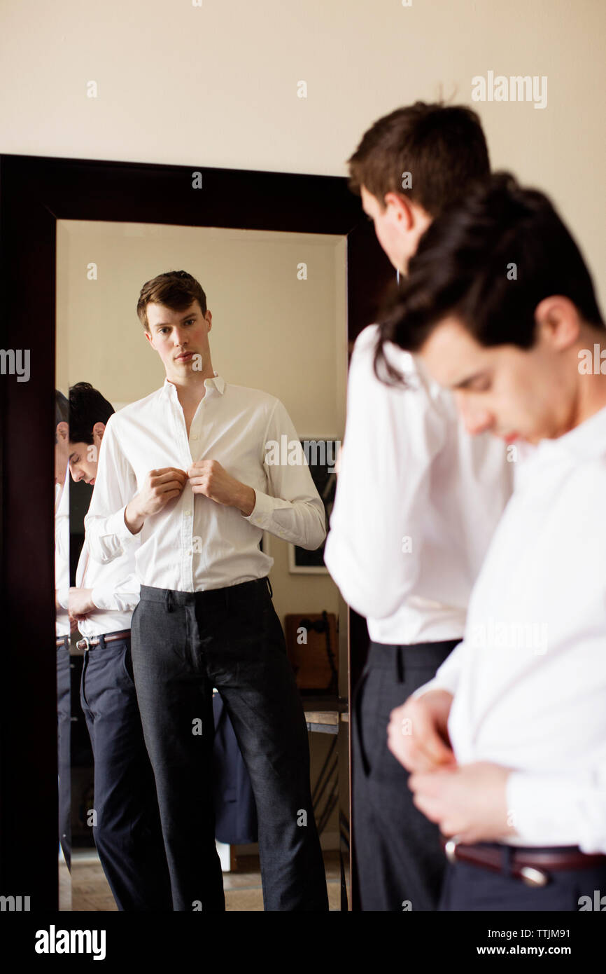 gay men getting dressed at home Stock Photo