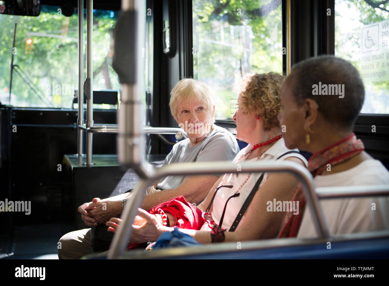 Women talking while traveling in bus Stock Photo